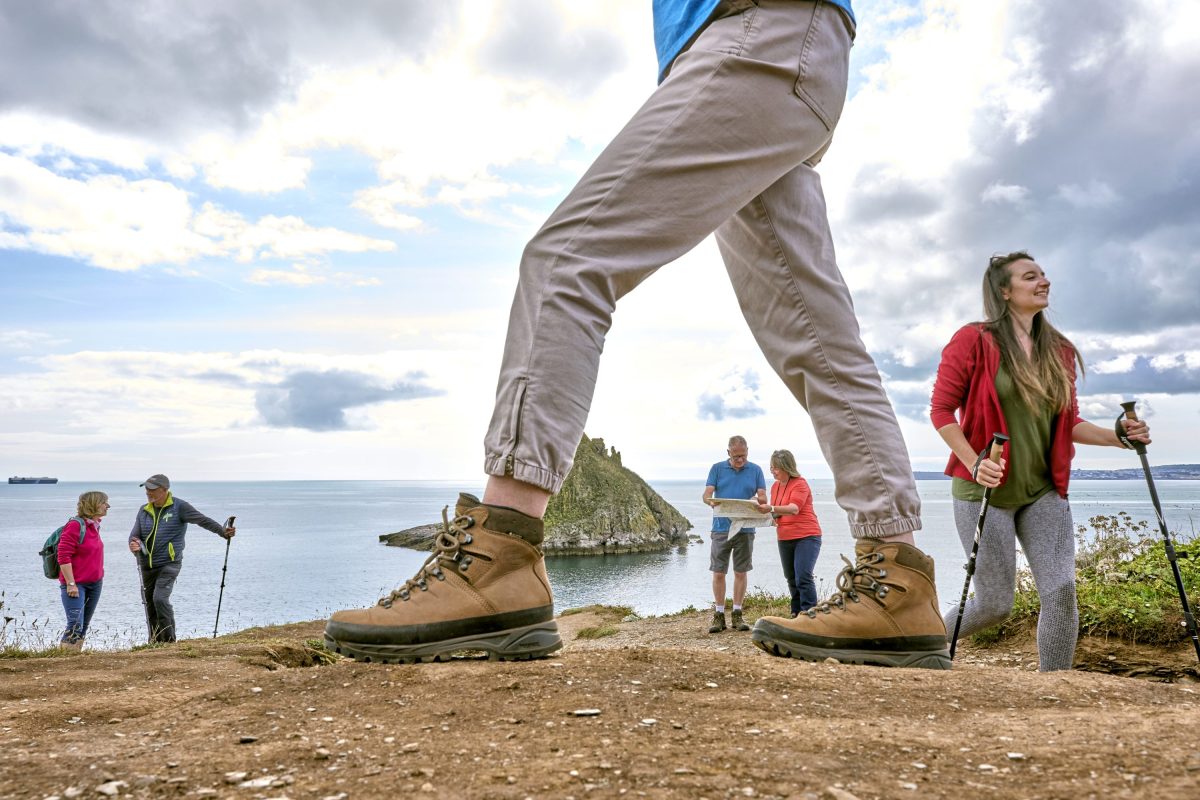 Walkers on a coastal path overlooking the South Devon sea