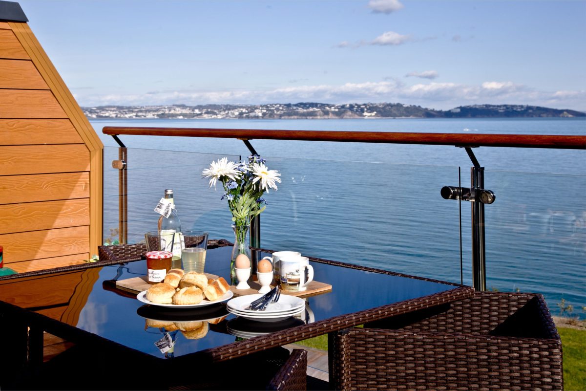 A traditional Devon cream tea served on a balcony overlooking the sea