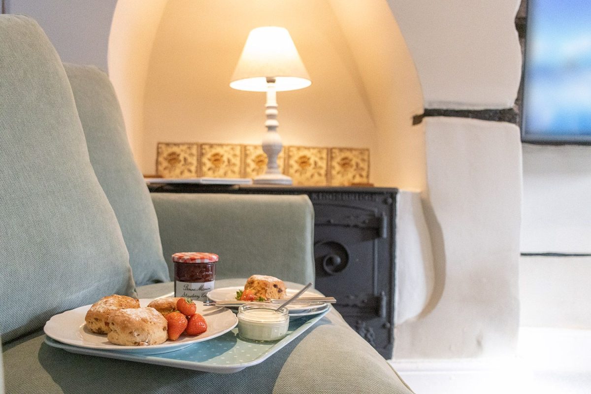A traditional Devon cream tea served on a tray in a comfortable holiday home