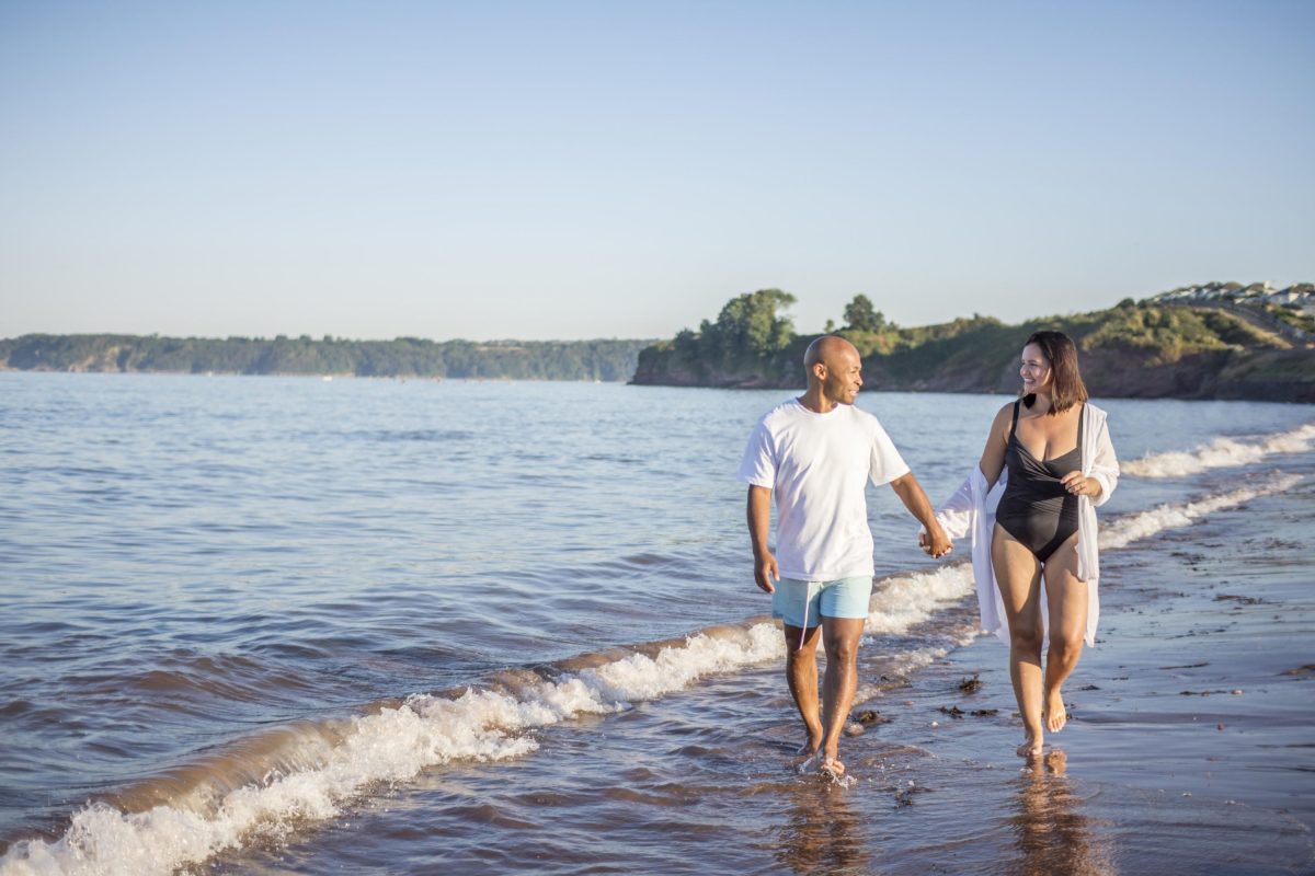 Couple takes a romantic stroll along Goodrington Beach 