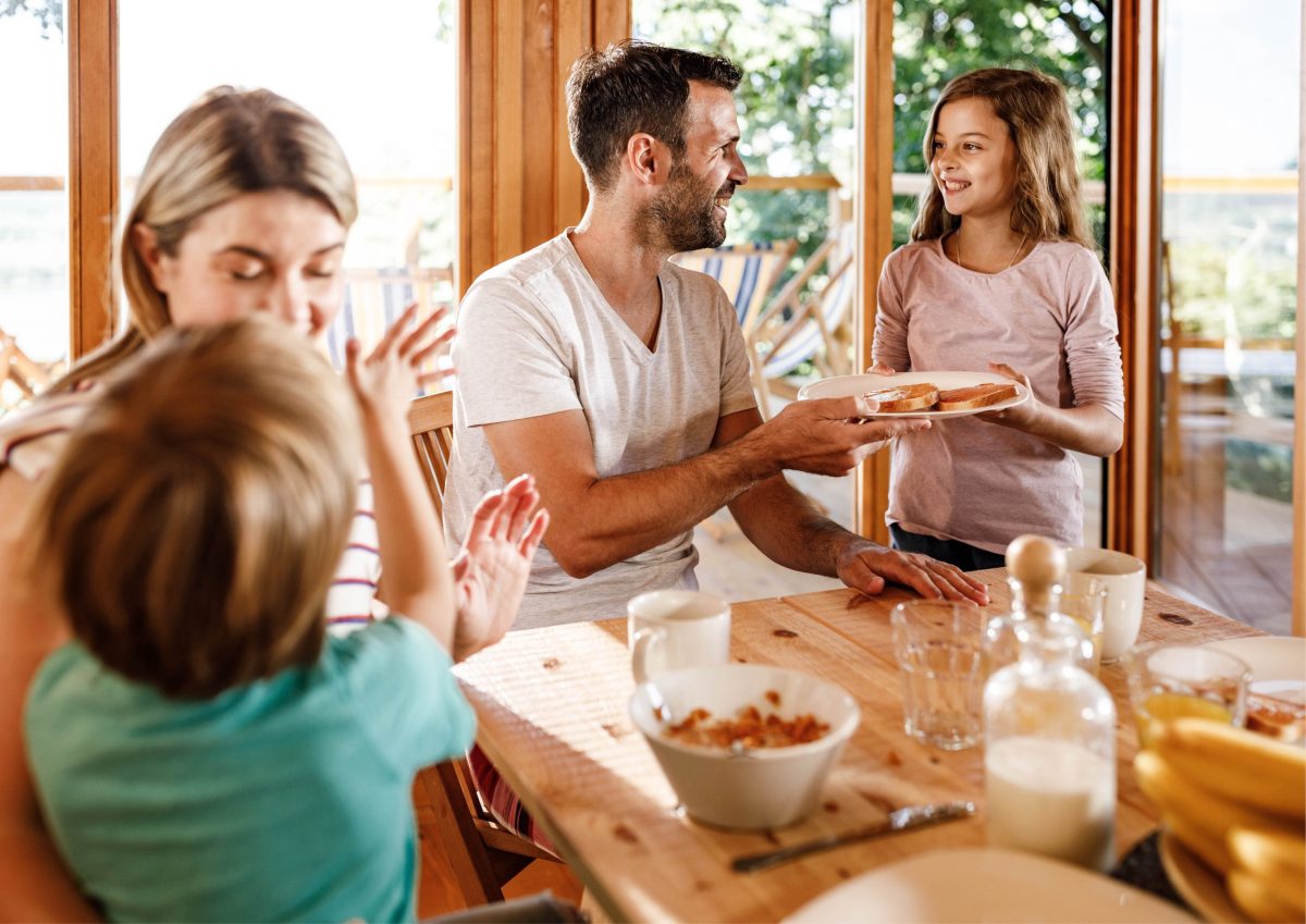 Happy family enjoying a meal together in a bright, welcoming holiday home dining area, creating warm and memorable moments