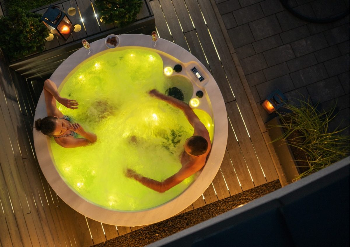 Couple relaxing in a hot tub on a crisp Autumn evening