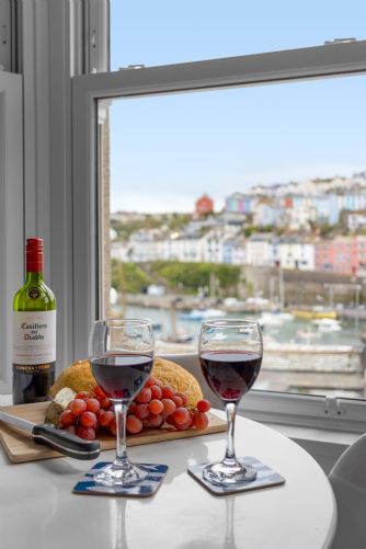 Inviting holiday home table setting with wine, crusty bread, and artisan cheeses to create a warm welcome for guests