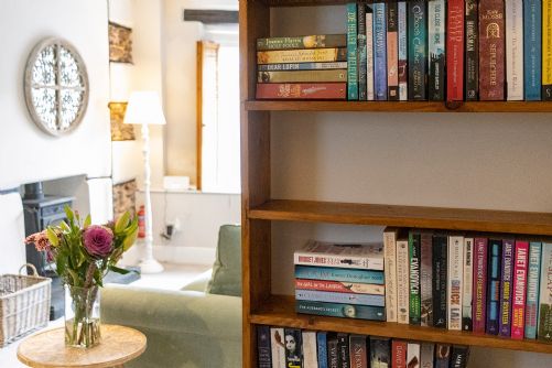 A bookshelf full of books in the lounge of a holiday home in South Devon