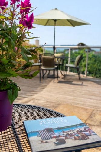 Relaxing holiday home outdoor space with a small plant and lifestyle magazine on the table, perfect for unwinding