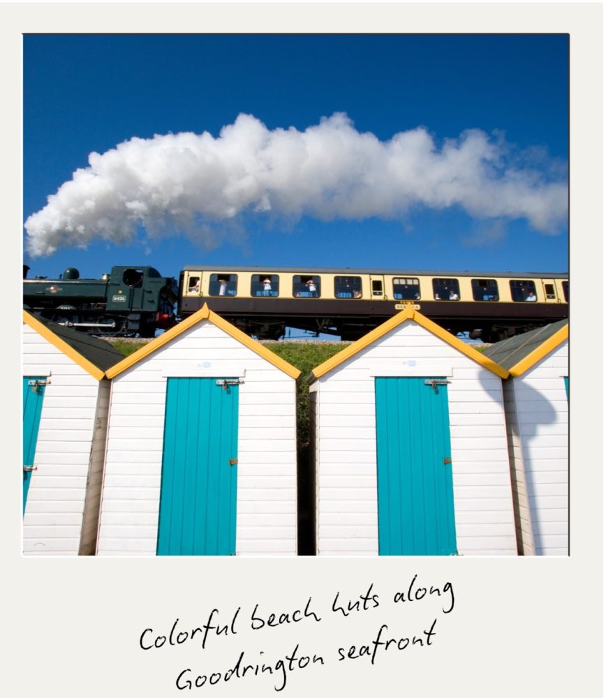Colourful beach huts on Paignton's Goodrington seafront with the steam train behind