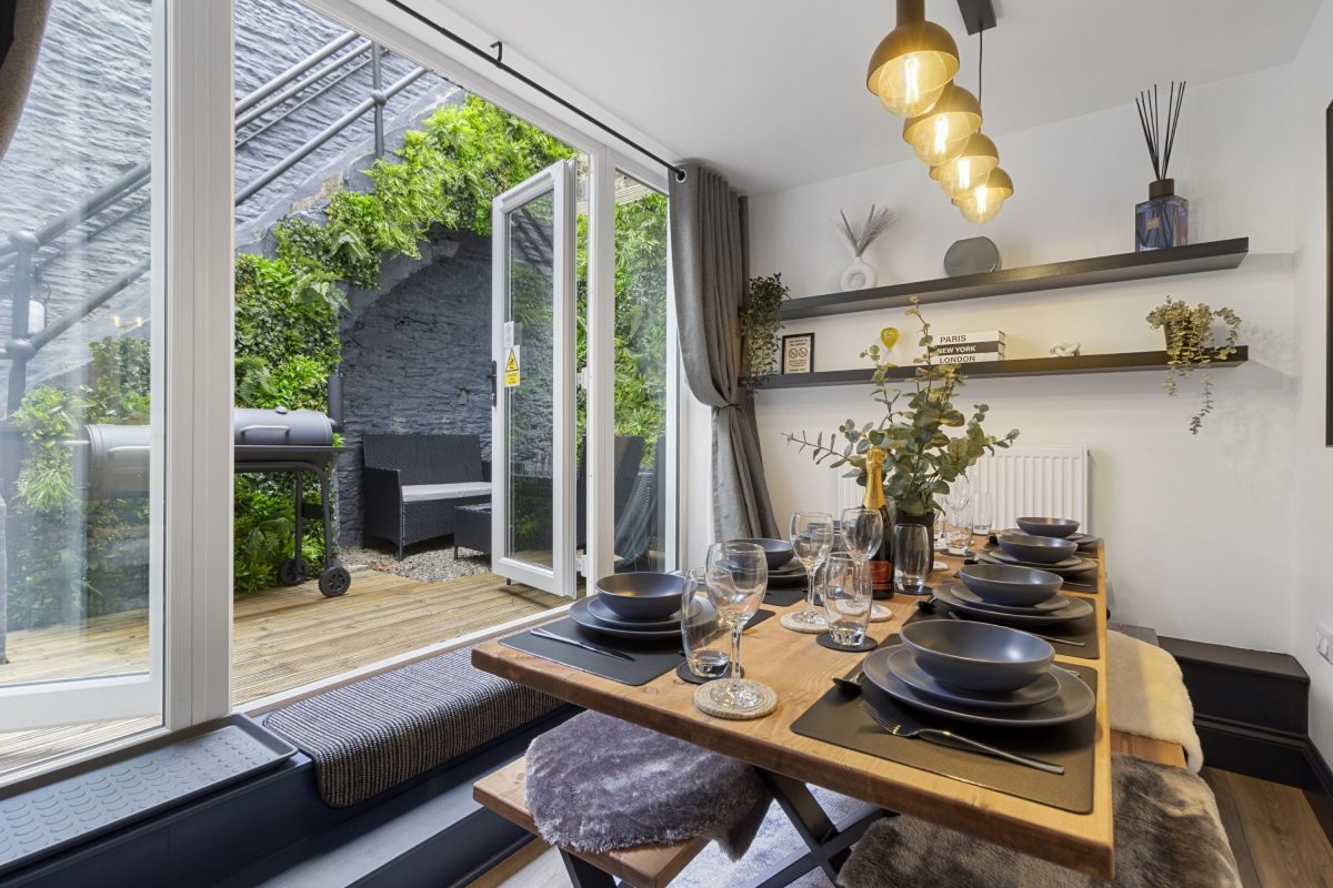 A dining table set up for dinner with crockery, cutlery and glasses in a holiday home in South Devon