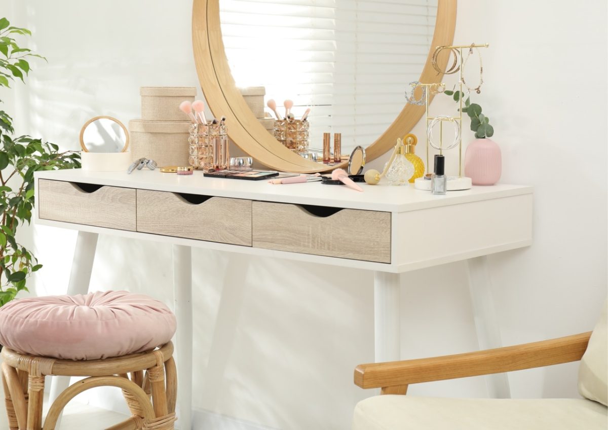 A dressing table in a holiday home in South Devon with make up, perfume, hair dryer, mirror and a stool