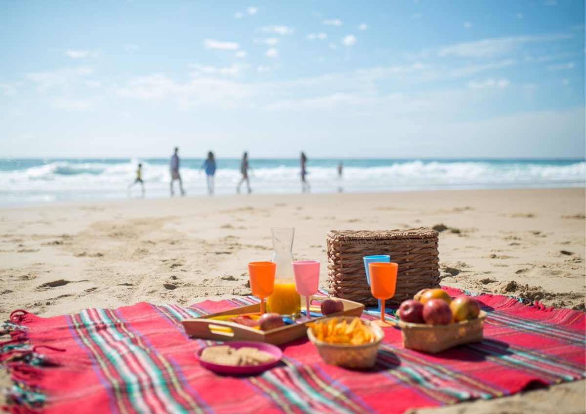 Family picnic set out on a picnic blanket on a South Devon beach
