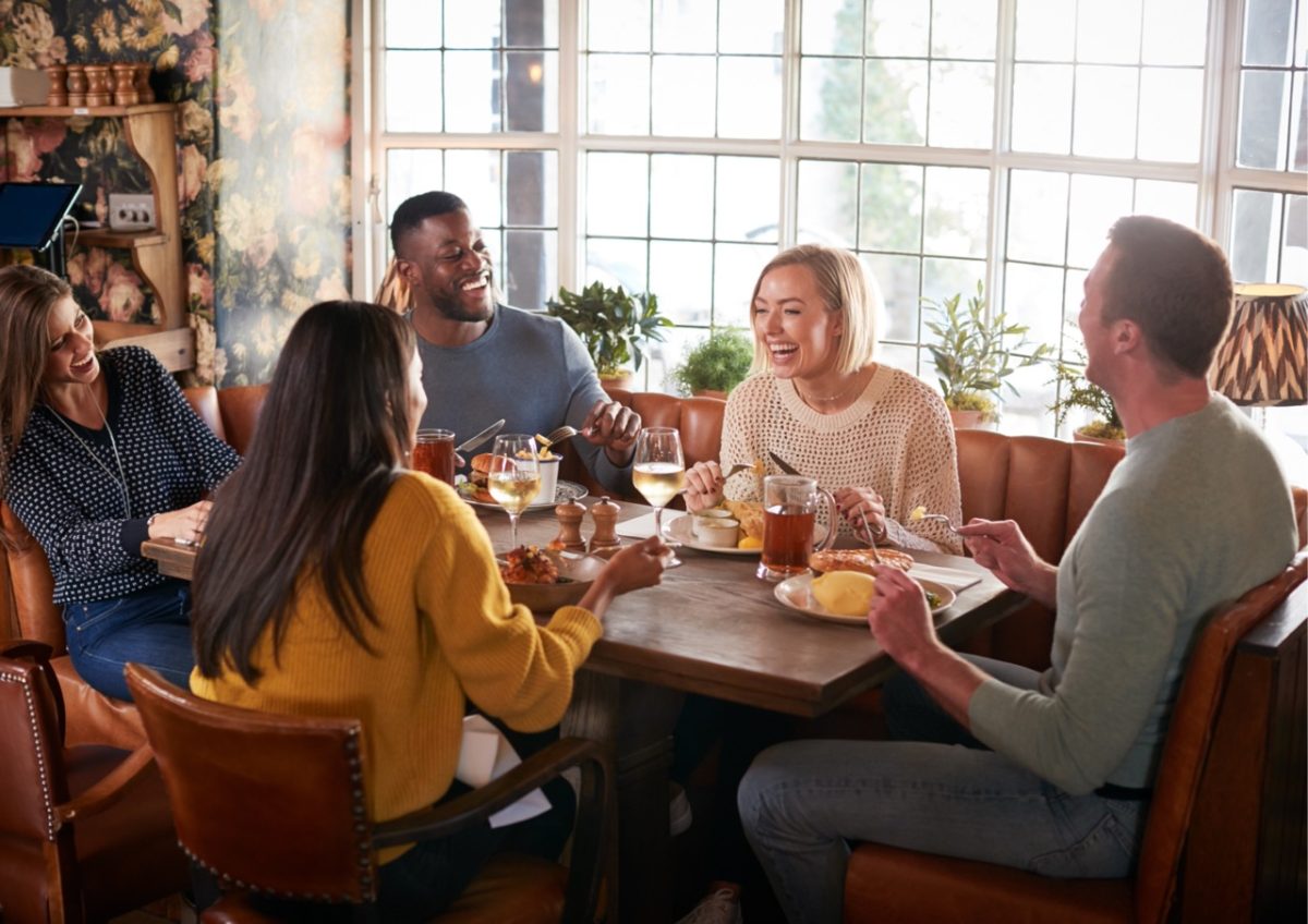 Friends enjoying a meal together in a pub in South Devon