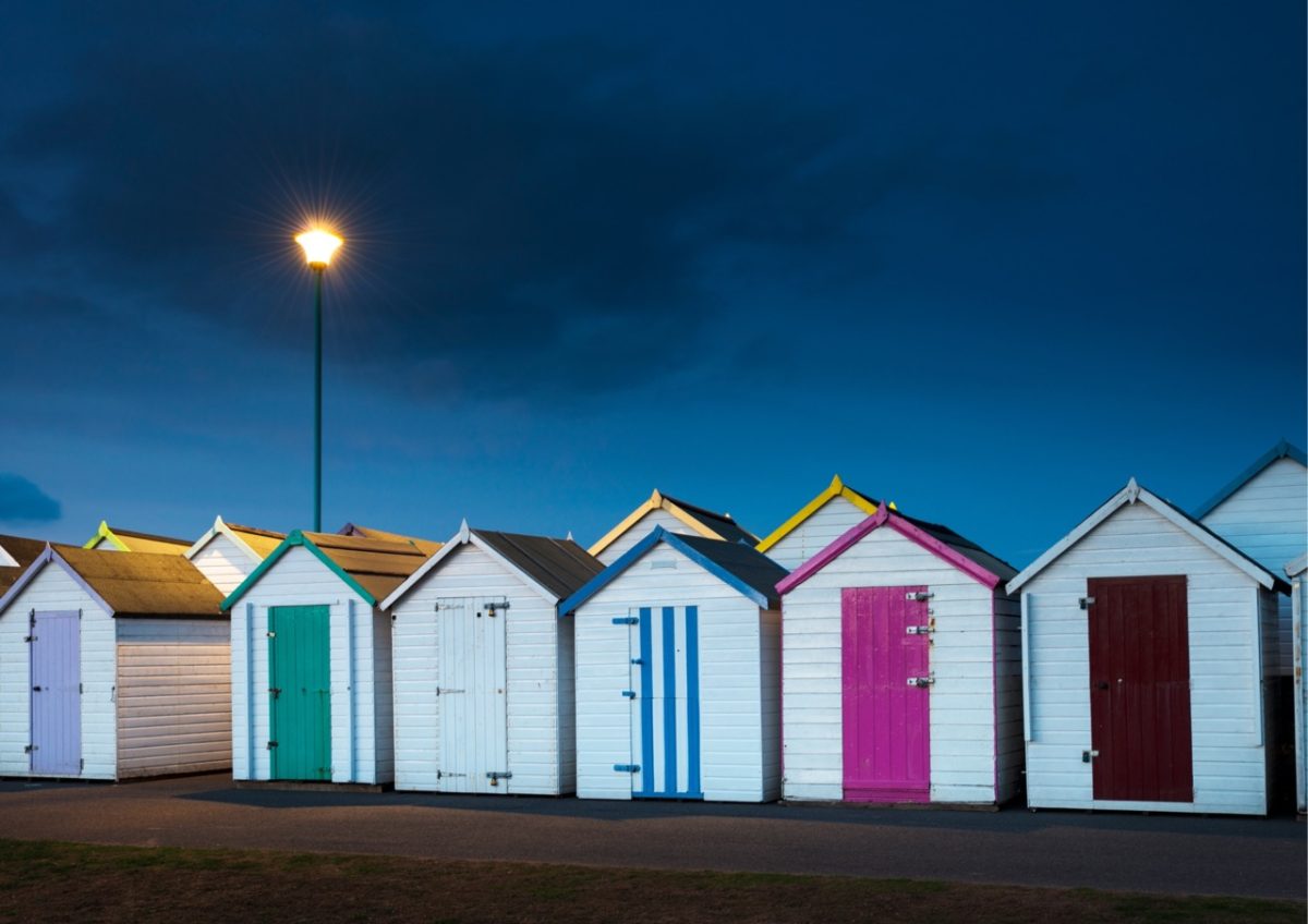 Row of colourful beach huts along the South Devon coast on a quiet winter evening