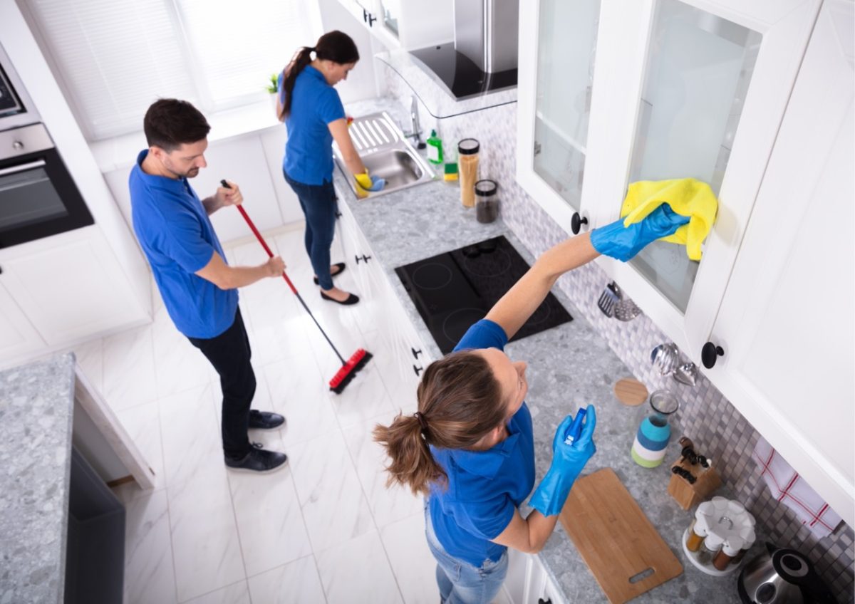 Cleaning team deep cleaning a holiday let kitchen during winter maintenance
