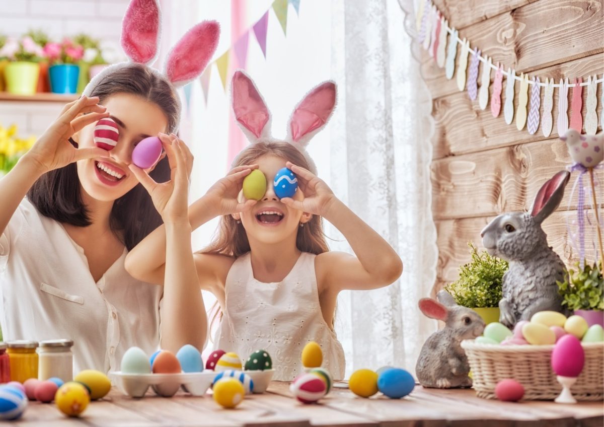 A mum and daughter wearing bunny ears and decorating eggs in a South Devon holiday home
