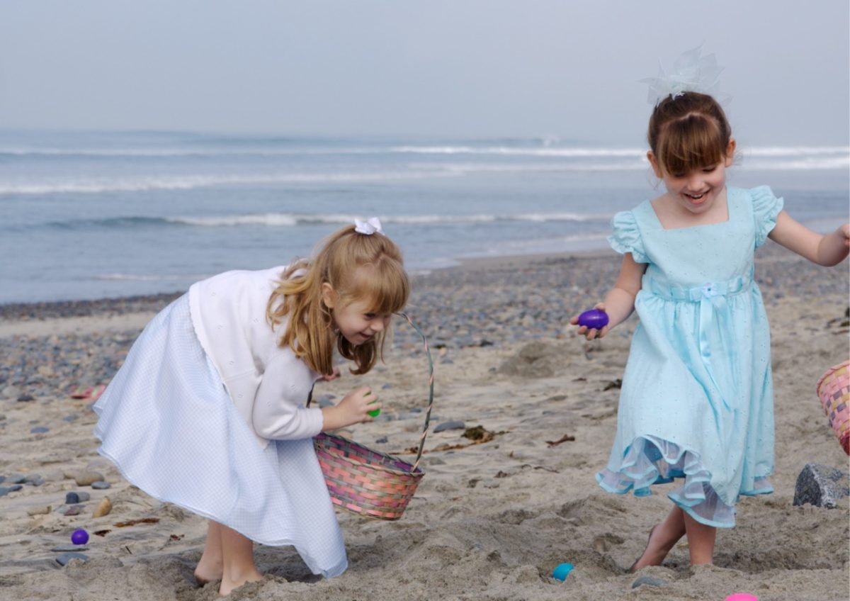 Two young girls collecting Easter eggs on a South Devon beach
